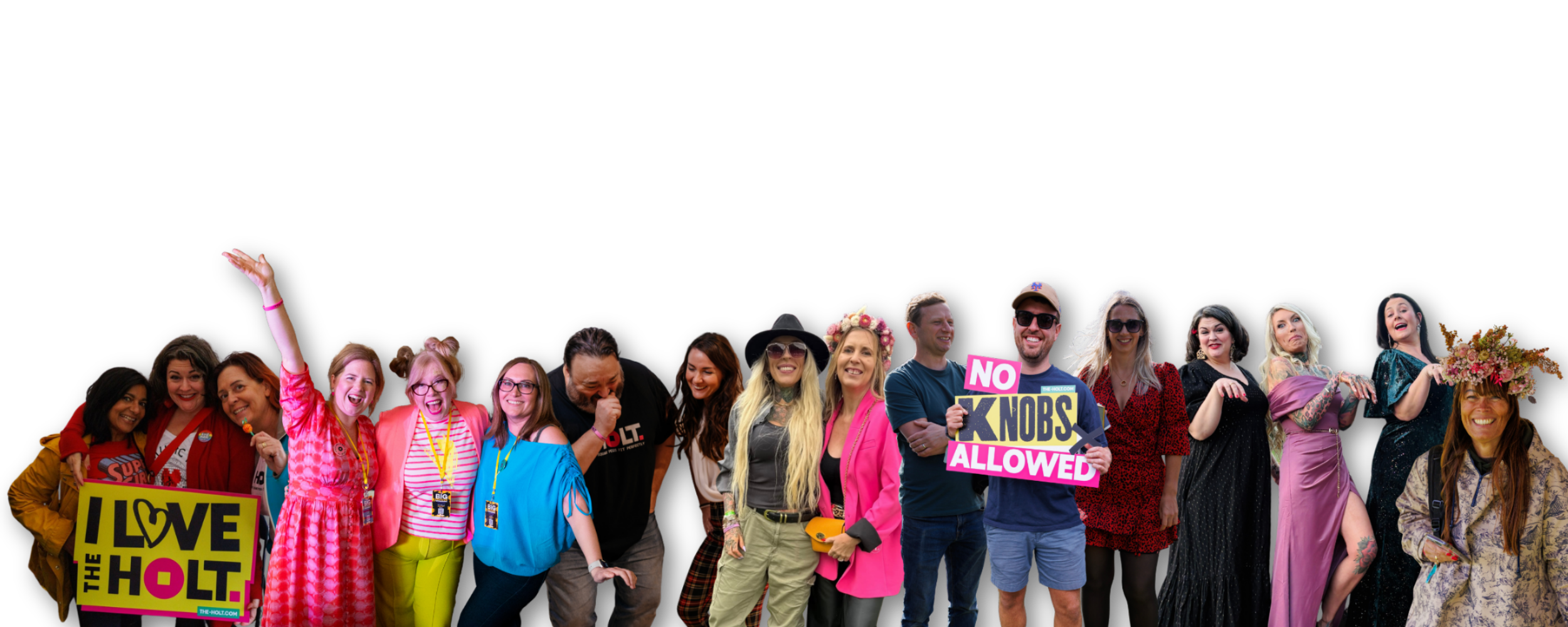 A diverse group of women and men smiling and posing together, some holding signs that say "I love the Holt" and "No knobs allowed," against a plain black background.
