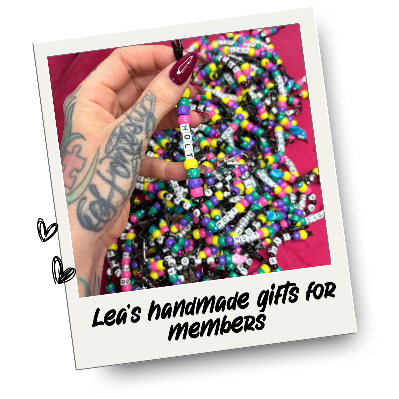 A person with tattoos on their hand holding a beaded keyring spelling 'HoLT' and the photo tag says "Handmade gifts from Lea"