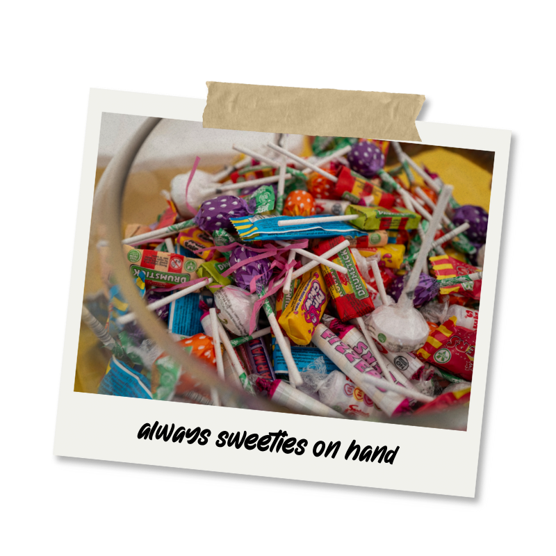A clear glass bowl filled with various candies, including lollipops and wrapped sweets, with a caption that says 'always sweeties on hand'.