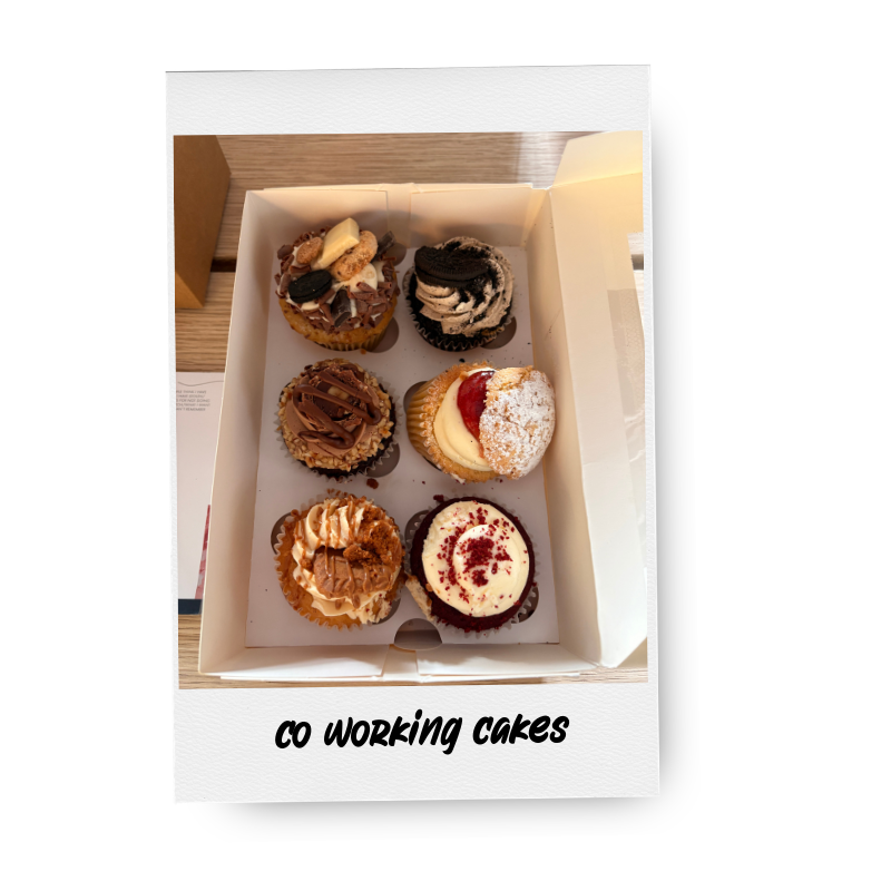 Six assorted cupcakes in a white box, each with different frosting and toppings, with text "CO WORKING CAKES" beneath.