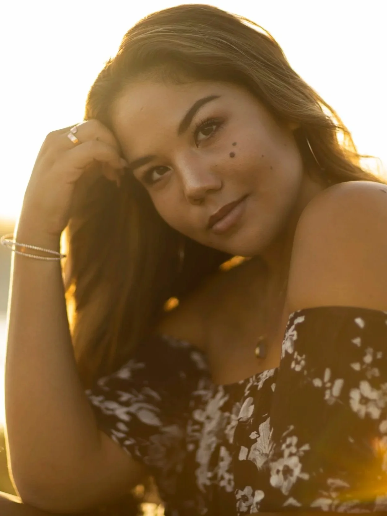 Outdoor graduation portrait of a smiling woman in golden light