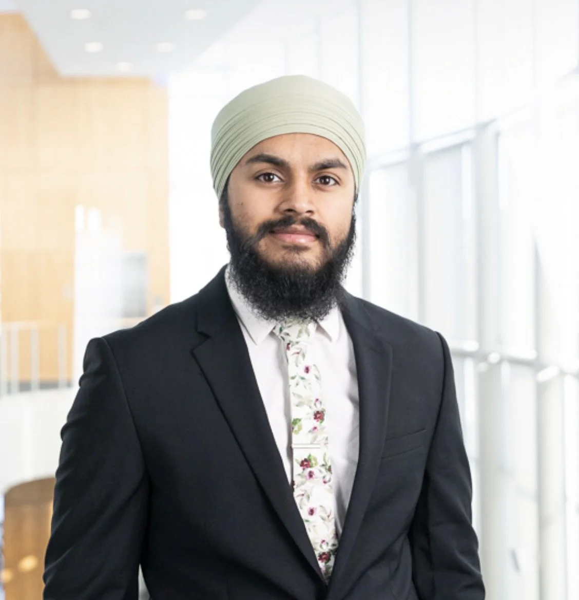 Dr. Amrit Singh, optometrist and founder of Bespoke Eye Care, standing in the office ready to serve patients.