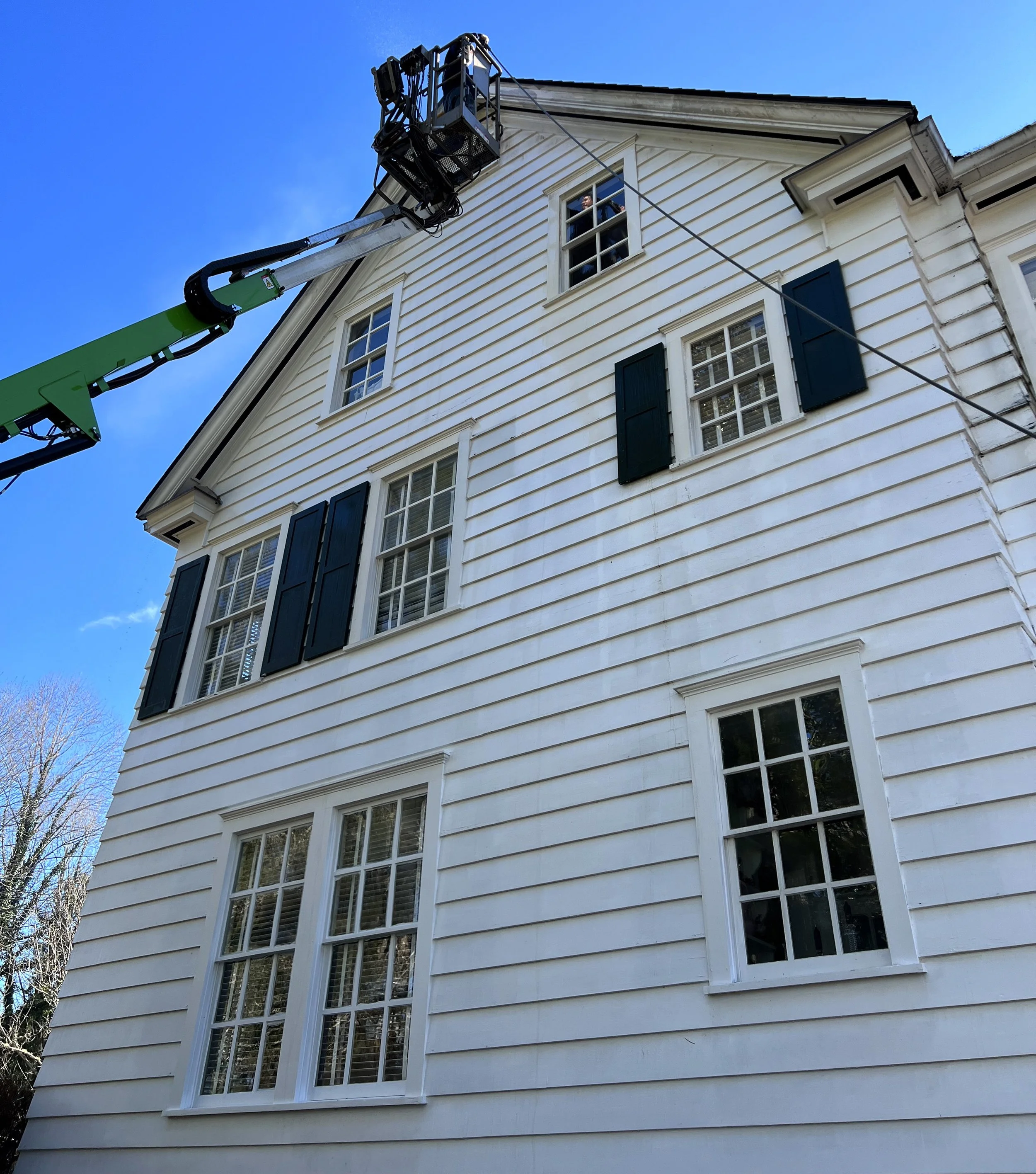 Using a man-lift to access the top of a 3-story house for pressure-washing