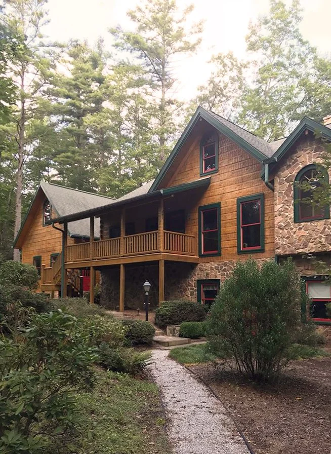 large log and stone house, freshly washed, stained and trim painted