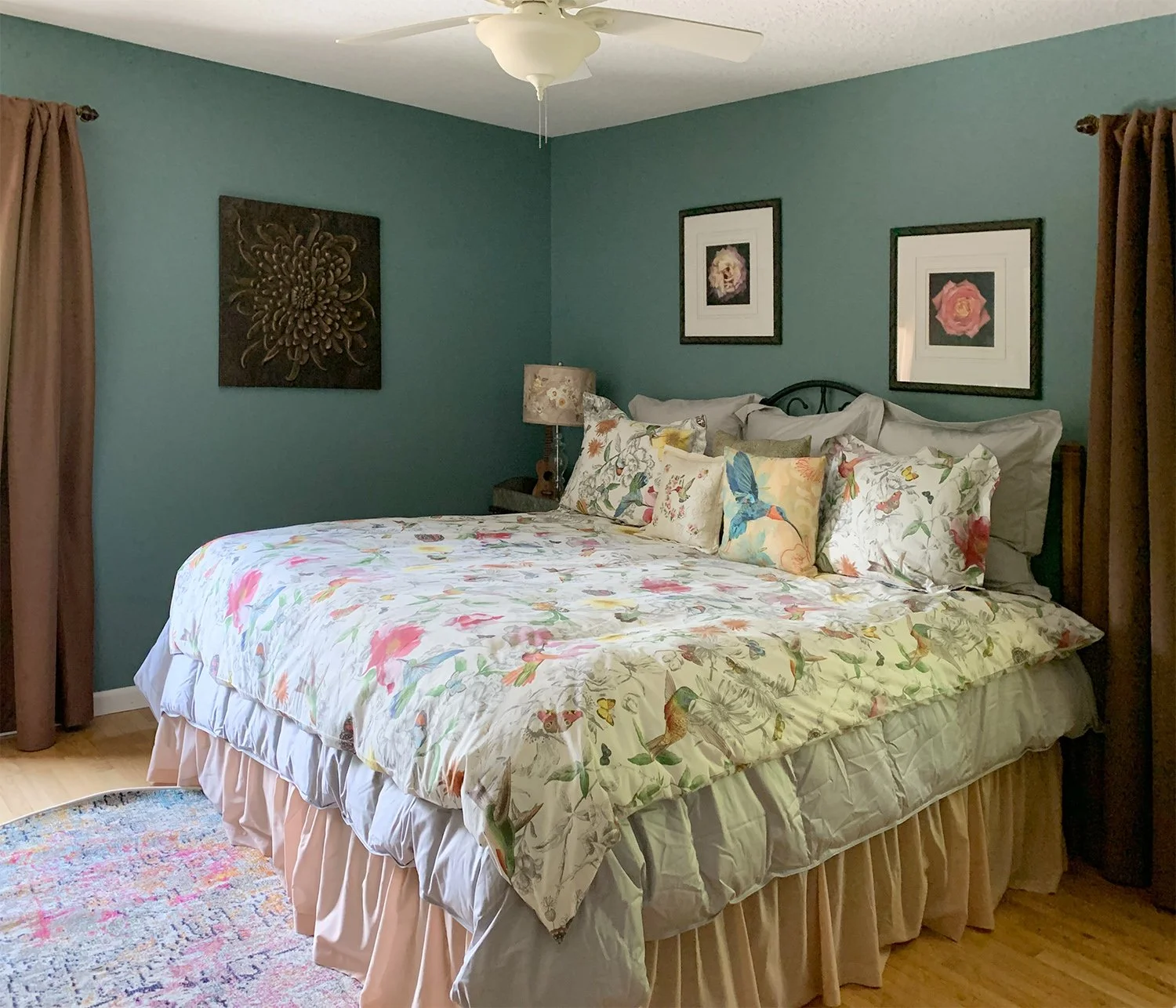 Lovely, calming teal walls complement the lively bedspread and rug in this bedroom