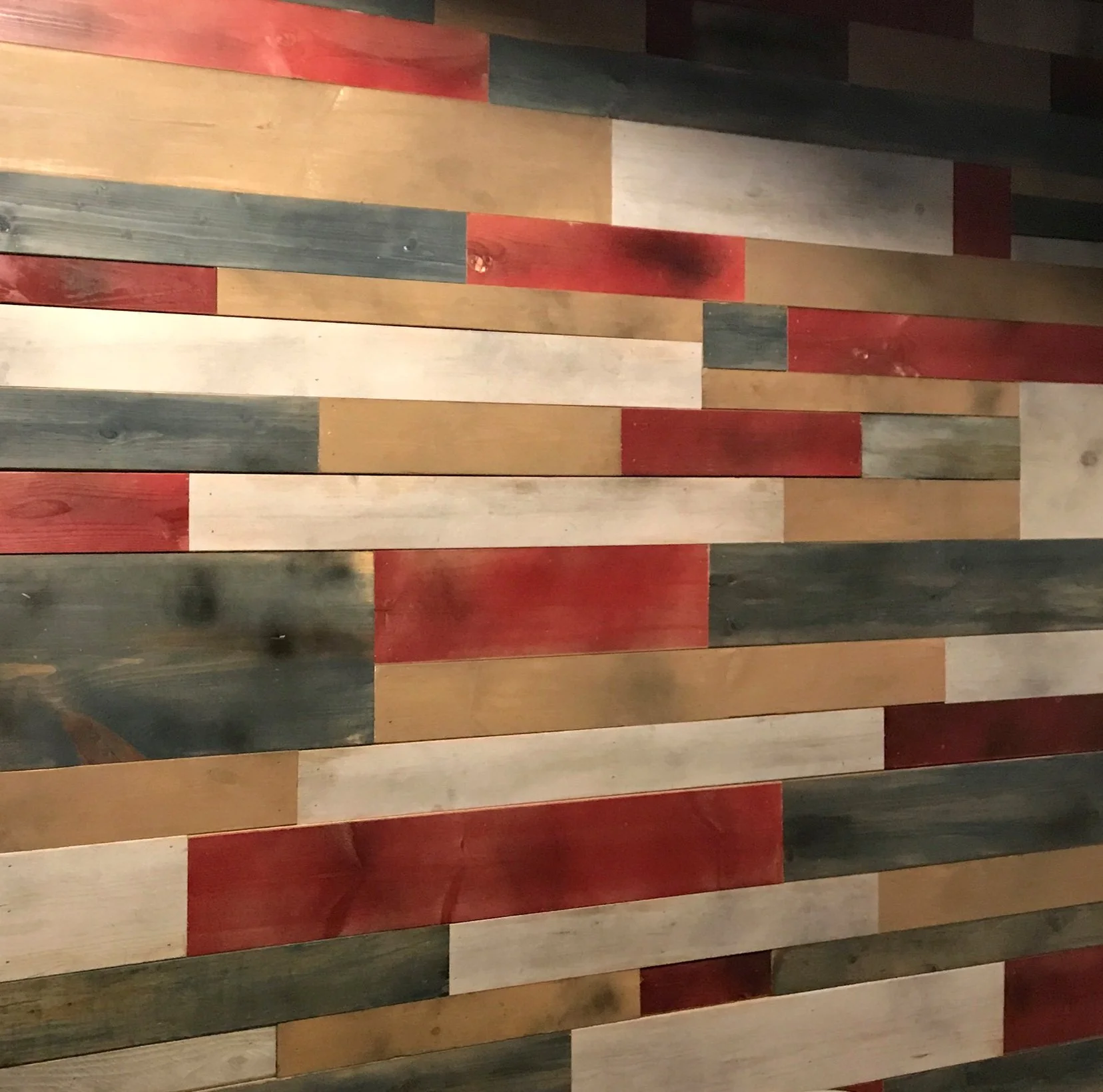 We used semi-solid stains on reclaimed wood to make the accent wall pop in this kids' playroom.