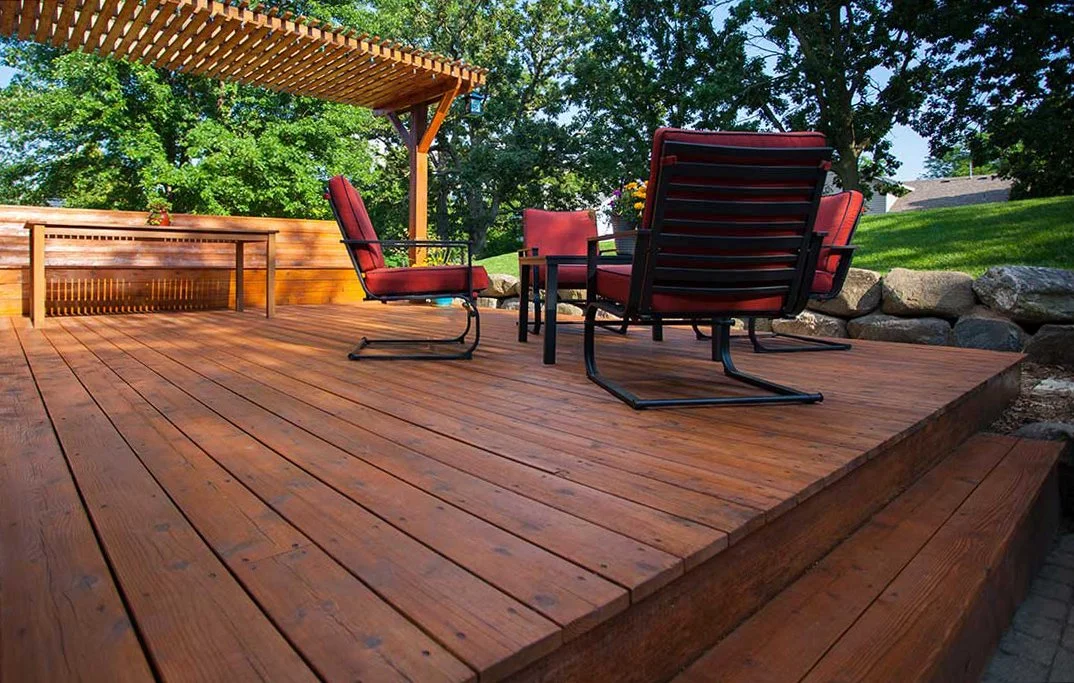 Beautifully refinished deck: cherry stain and red chairs