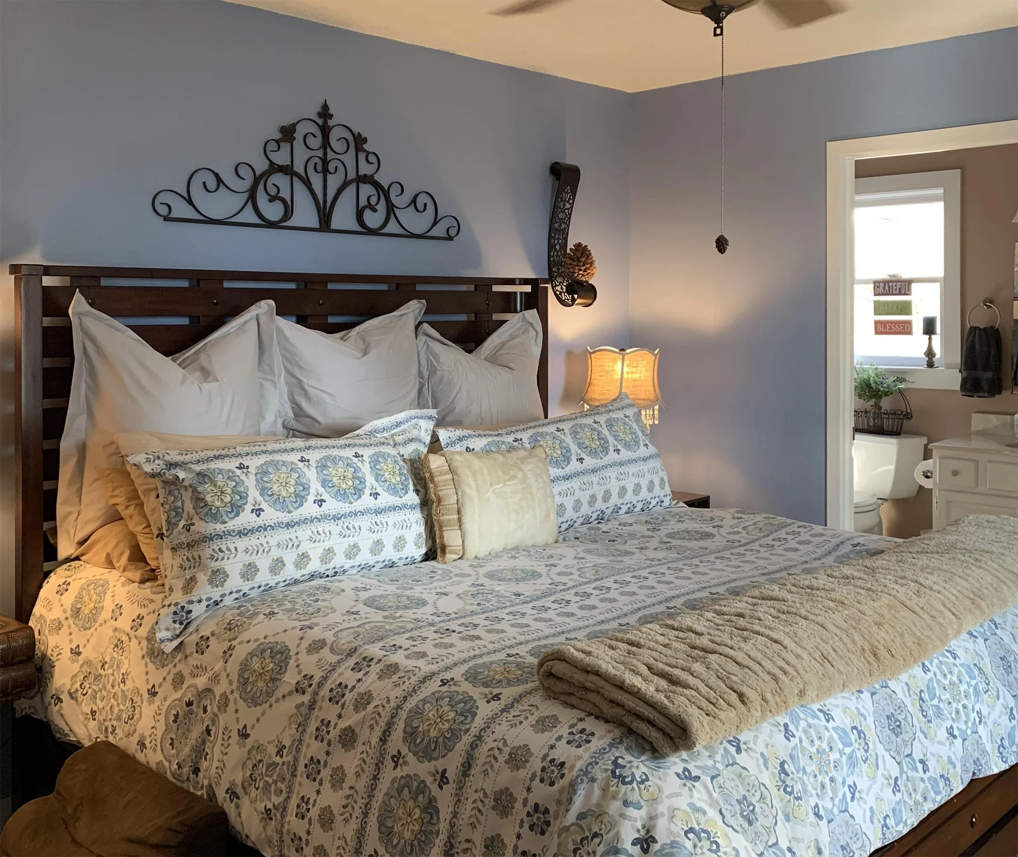 Calming blue-walled bedroom with complementary warm tones in the bath. We painted the entire interior of this 4-bed 3-bath home in Cullowhee, NC — each room with its own color palette.