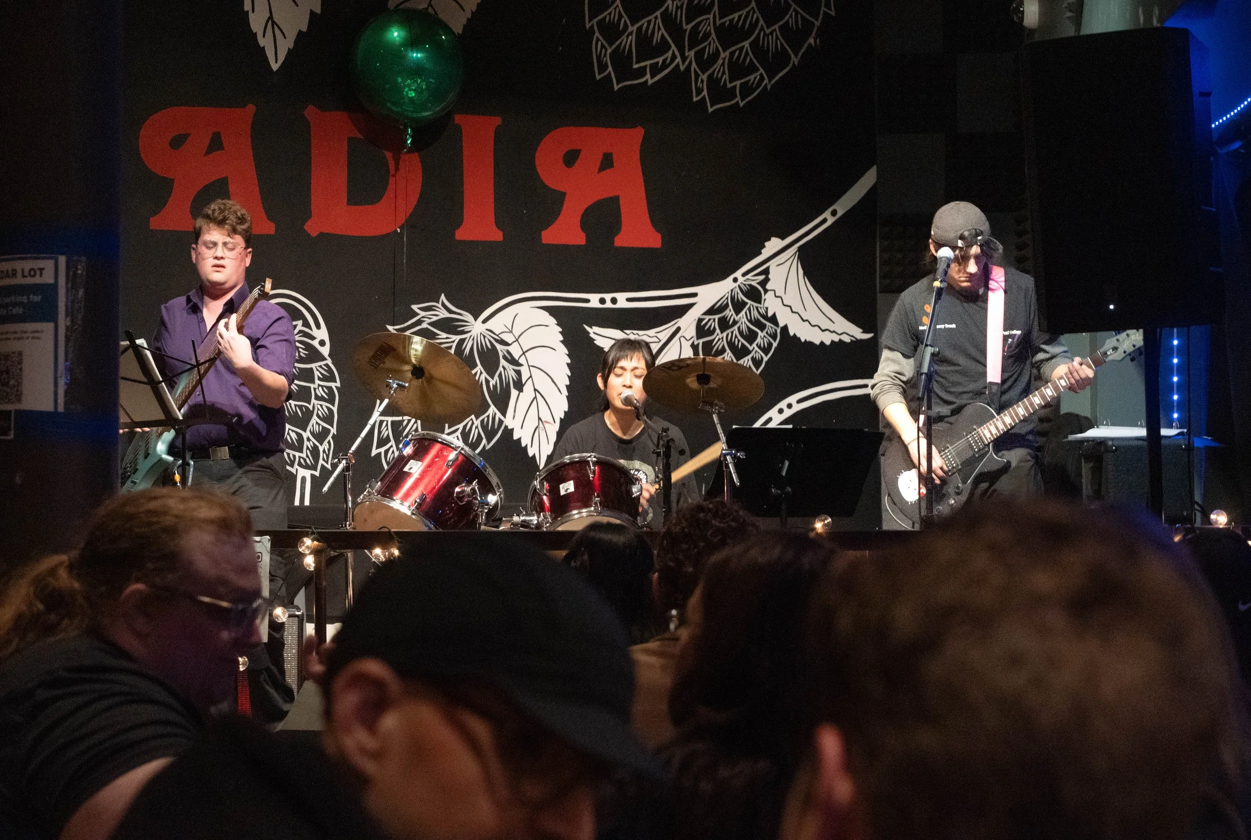 Indie band False Start, made up of Paul LePage, left, on bass, Maria Arriola on drums and vocals, and Liam Neiwert on guitar, plays their first concert at at venue, Acadia bar and grill, on Nov. 20, 2025, in Minneapolis, Minn. Neiwert said the three 