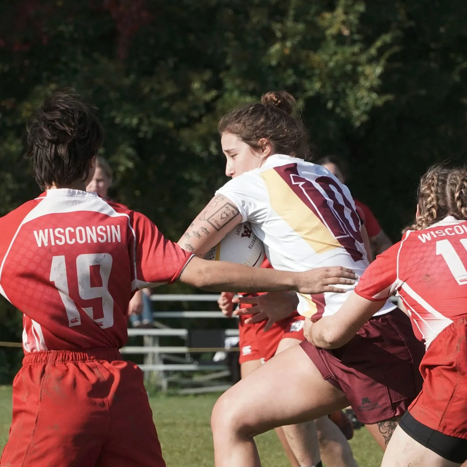 Gopher Women's Rugby player Mya Yourczek pushes past her opponents on the Wisconsin team during their game in Saint Paul, Minn., n Oct. 18, 2025.
