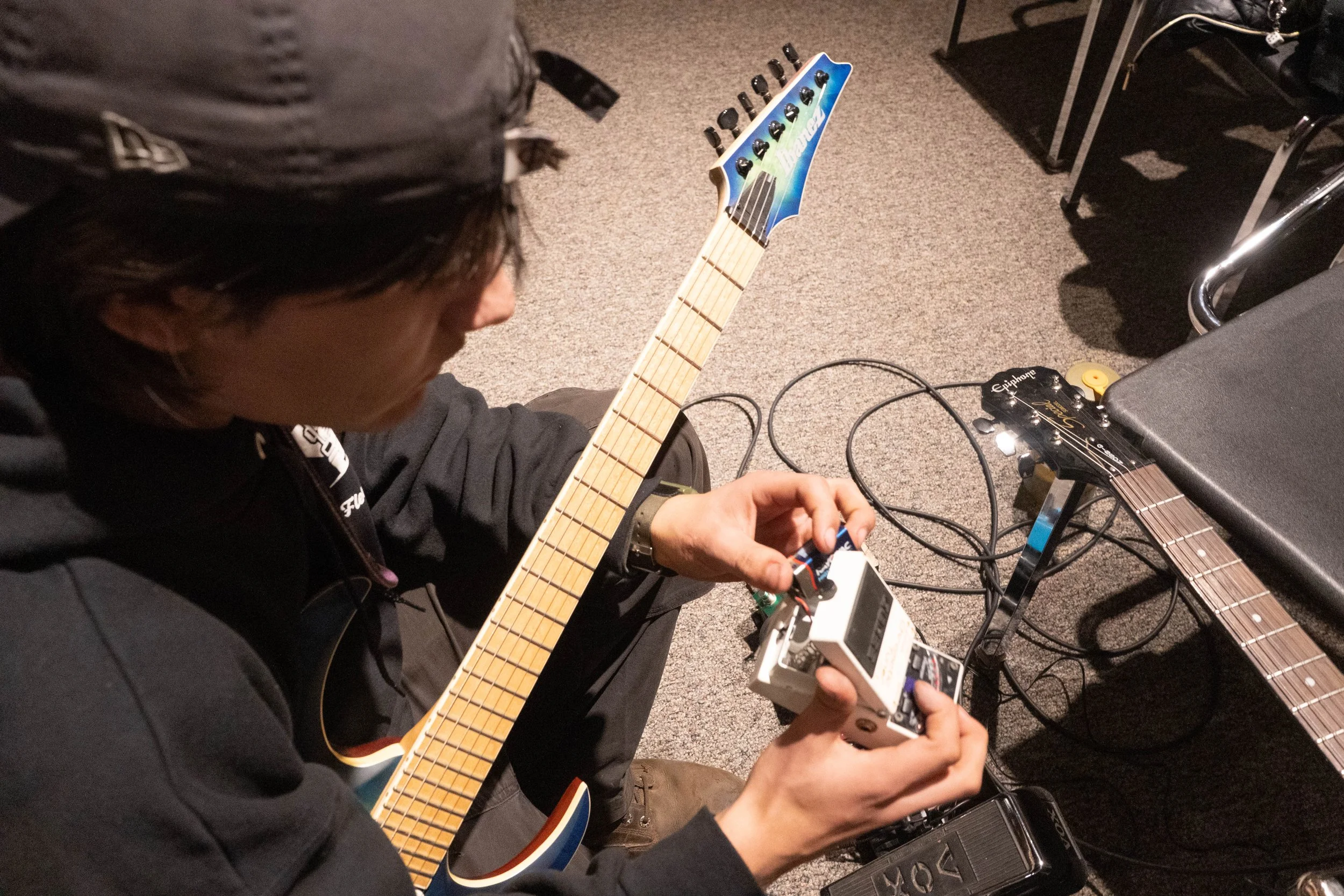 False Start guitarist Liam Neiwert switches out the batteries in one of his guitar pedals before beginning the band's practice and recording session in Ferguson Hall at the University of Minnesota in Minneapolis, Minn., on Nov. 24, 2025. Neiwert's ba