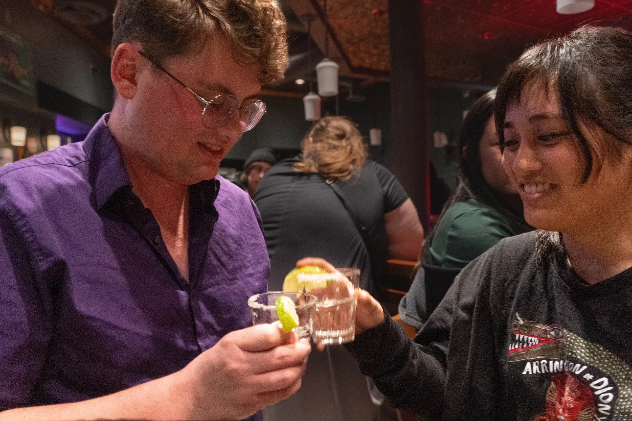 Romantic partners and bandmates Paul LePage, left, and Maria Arriola drink a celebratory shot after their performance at Acadia bar and grill in Minneapolis, Minn., on Nov 20, 2025. Their friend had purchased drinks for all three band members, but fo
