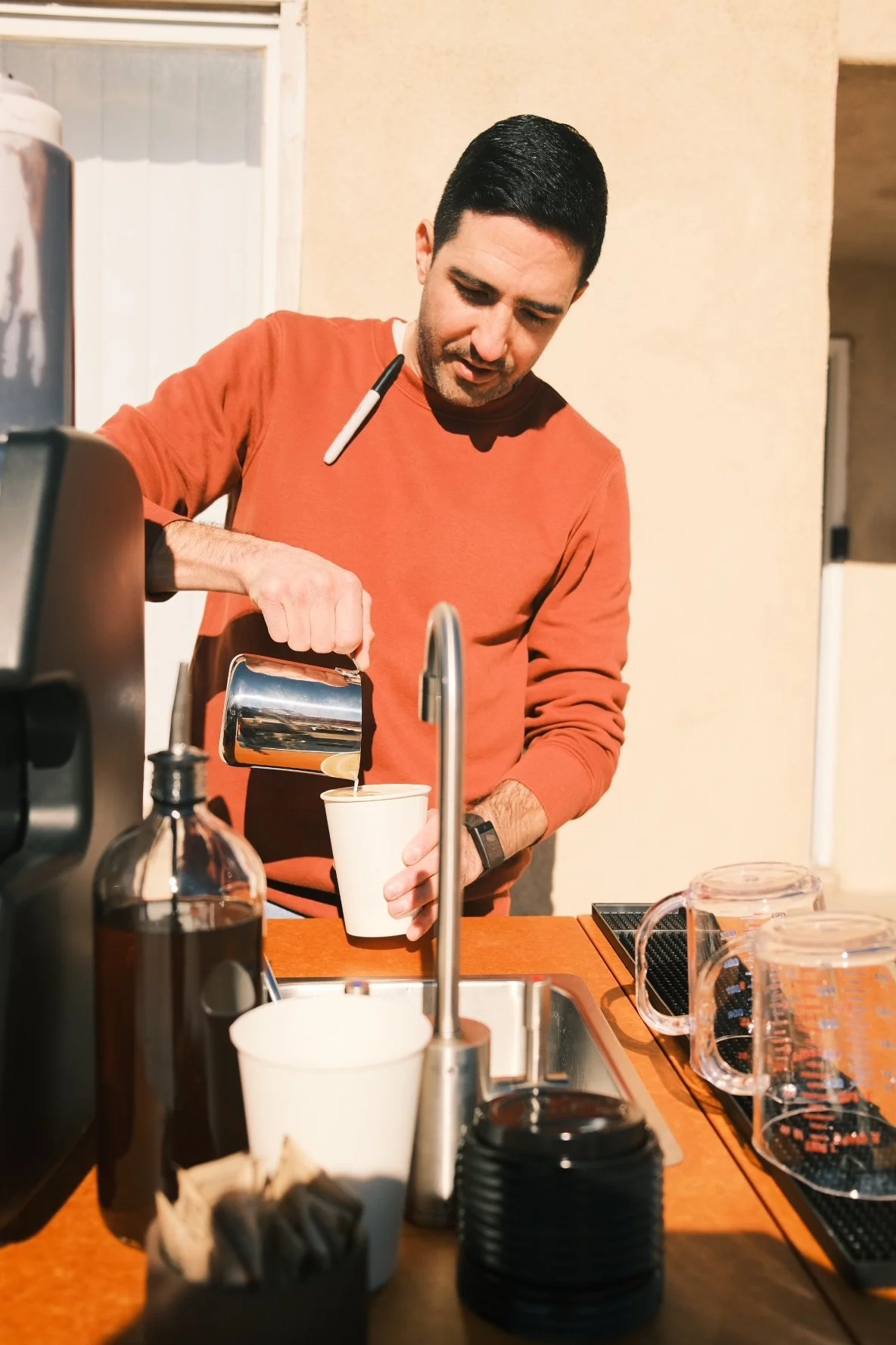 Barista pouring steamed milk into cup