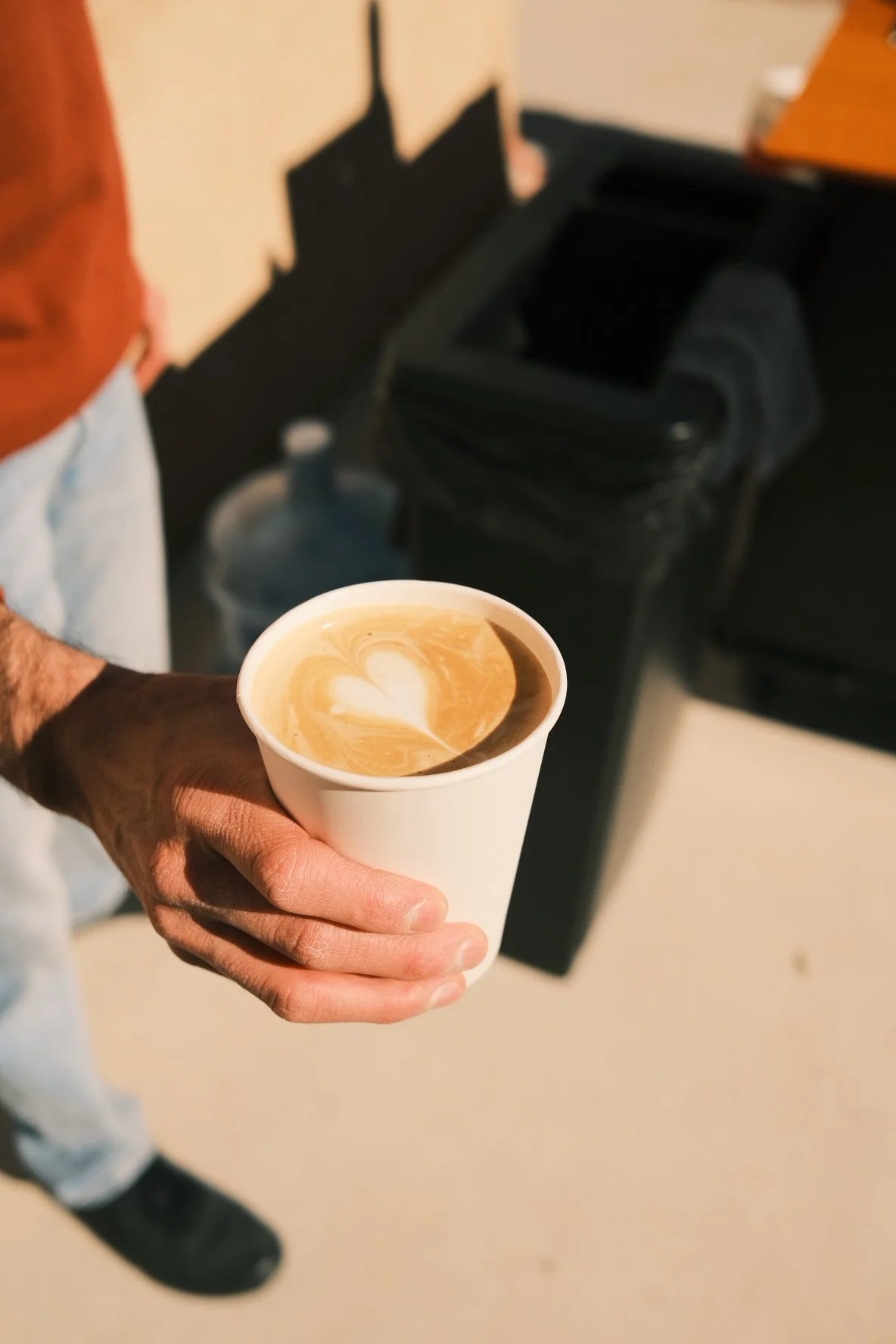 Barista handing drink to customers. Heart in Latte art.
