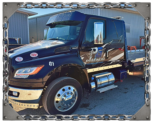 A car on a tow truck at sunset with a chain border around the image.