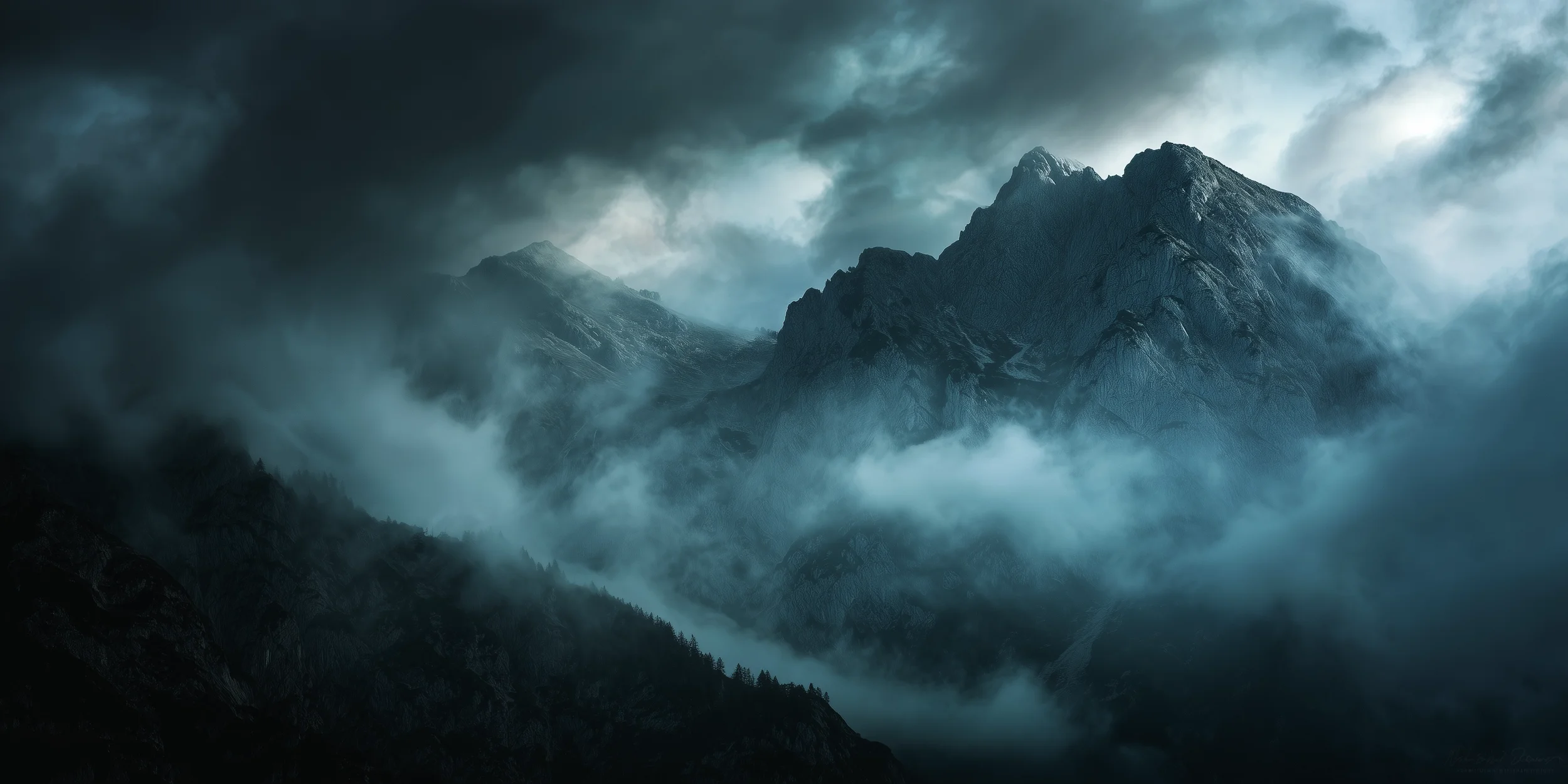 Zerklüfteter Berg in einem bedrohlichen blaugrauen Wolkennebel, bewaldete Bergspitzen im Vordergrund