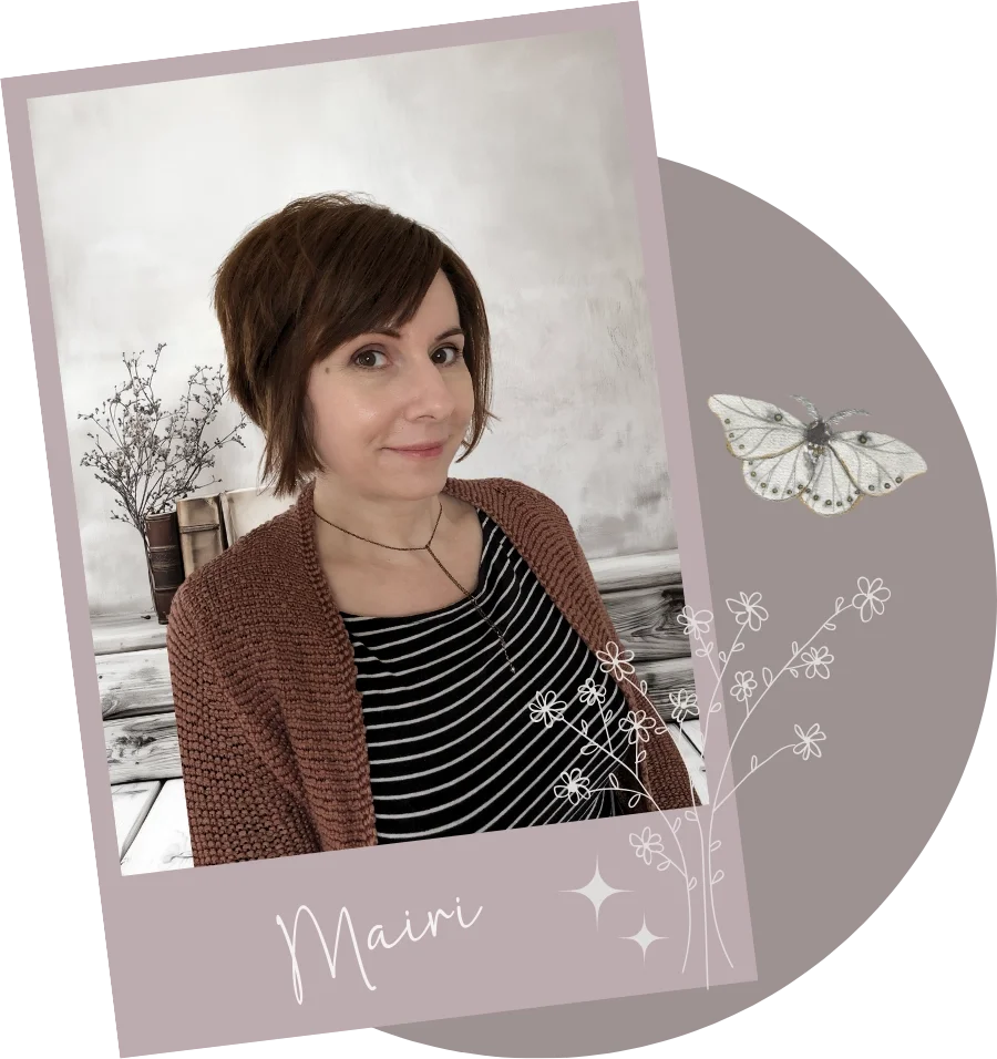 Porträt der Autorin Mairi Carlsson. Sie steht vor einer hellen Wand mit dekorativen Zweigen in einer Vase im Hintergrund.