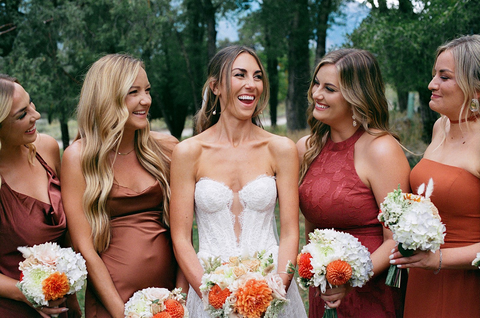A bride and her bridesmaids carrying coordinated bouquets of farm-grown dahlias and seasonal blooms from Cherokee Bloom — grown at 7,200 feet in Salida, Colorado.
