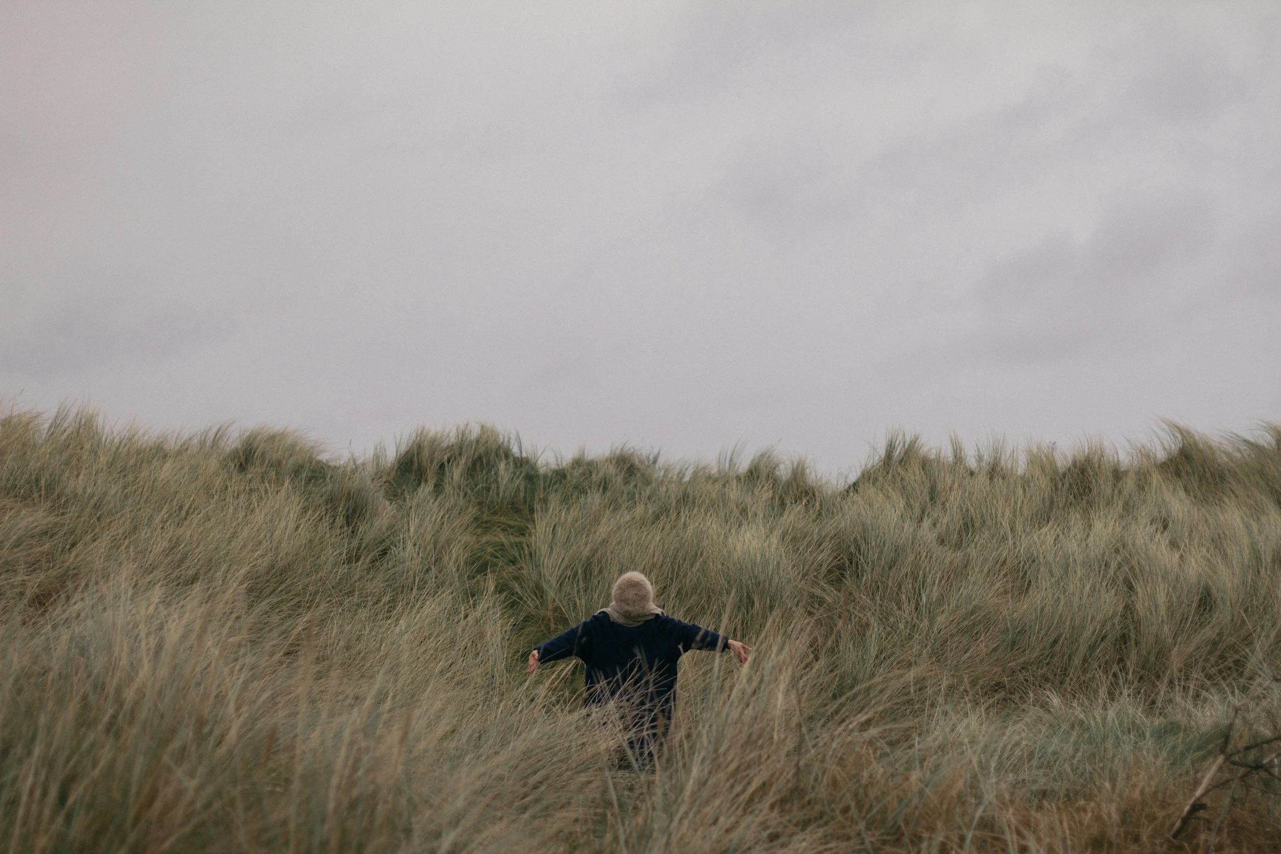 Woman appearing enthusiastic standing in field.