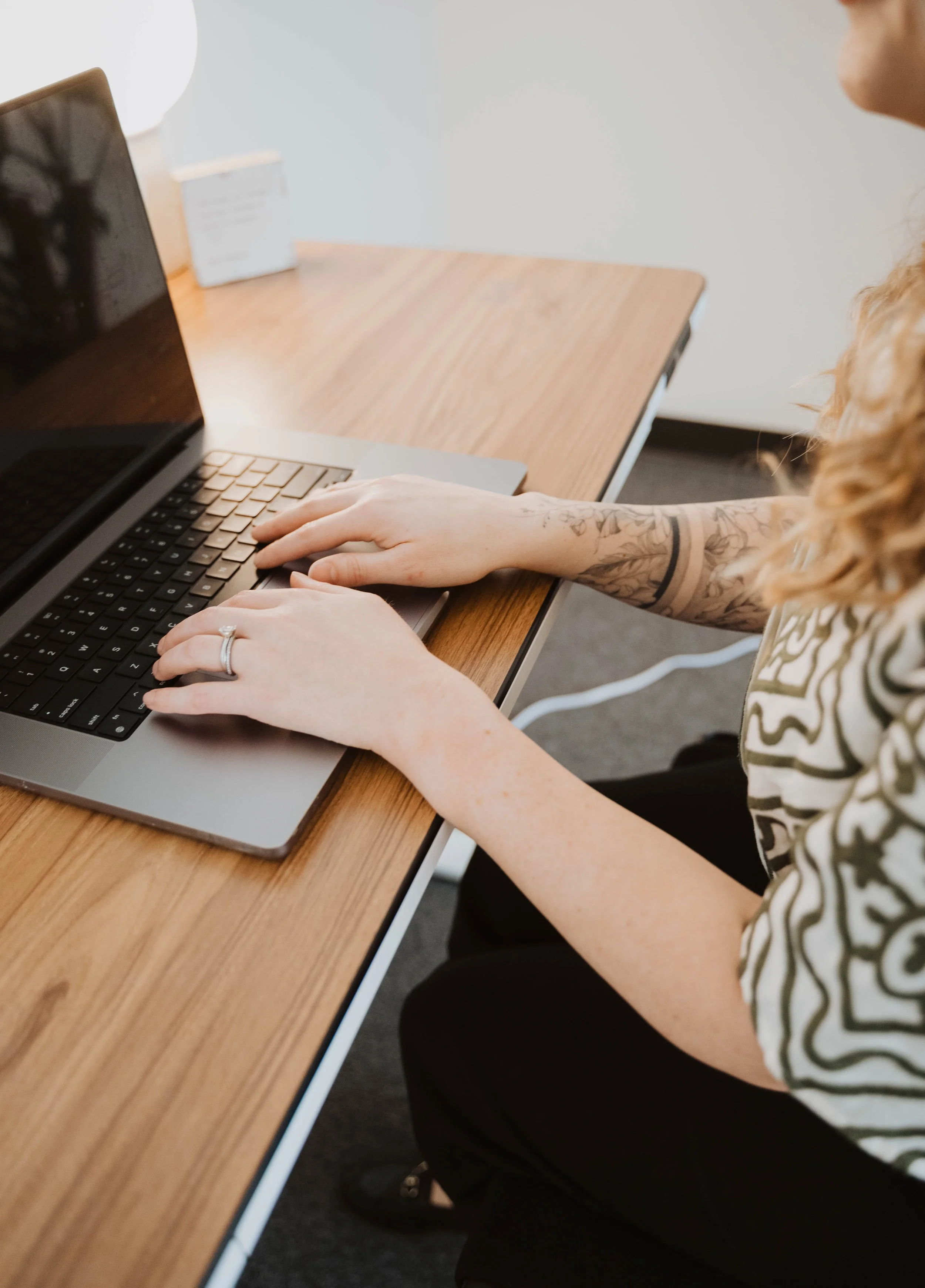 Woman sitting at laptop, offering HIPAA compliant telehealth services.