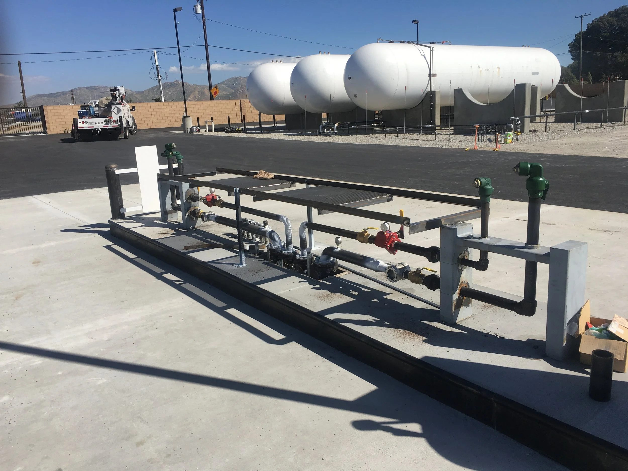 30,000 gallon LP storage tanks on concrete supports at an outdoor facility, with a transport offloading system in the foreground.