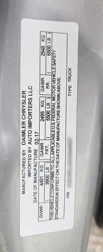 Vehicle identification and safety information label with weight and manufacturing details for a Daimler Chrysler vehicle.