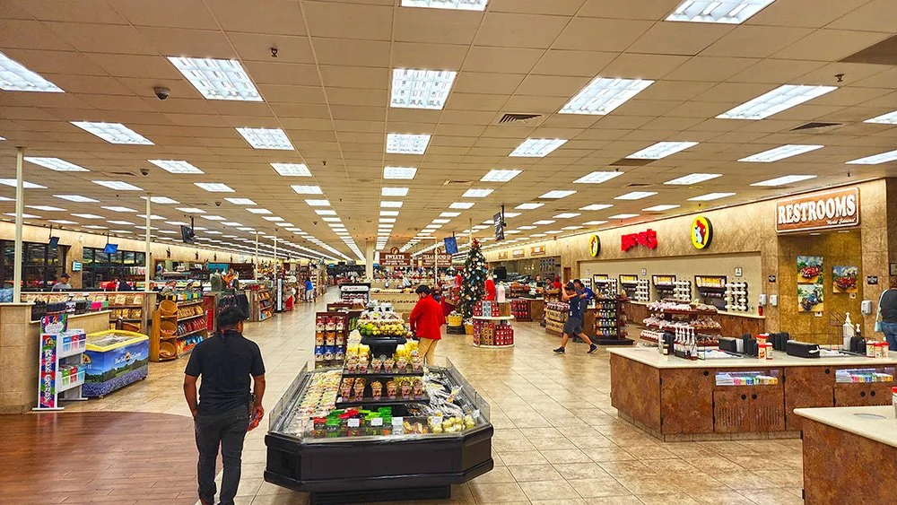 Inside a Buc-ee's at night.   The restrooms are to the right, food in the middle, and just a few people walking around.  It is not busy here right now.