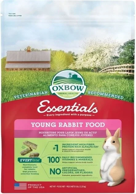 Packaging of Oxbow Essentials Young Rabbit Food with a white rabbit illustration, a barn, green grass, and flowering tree in background.