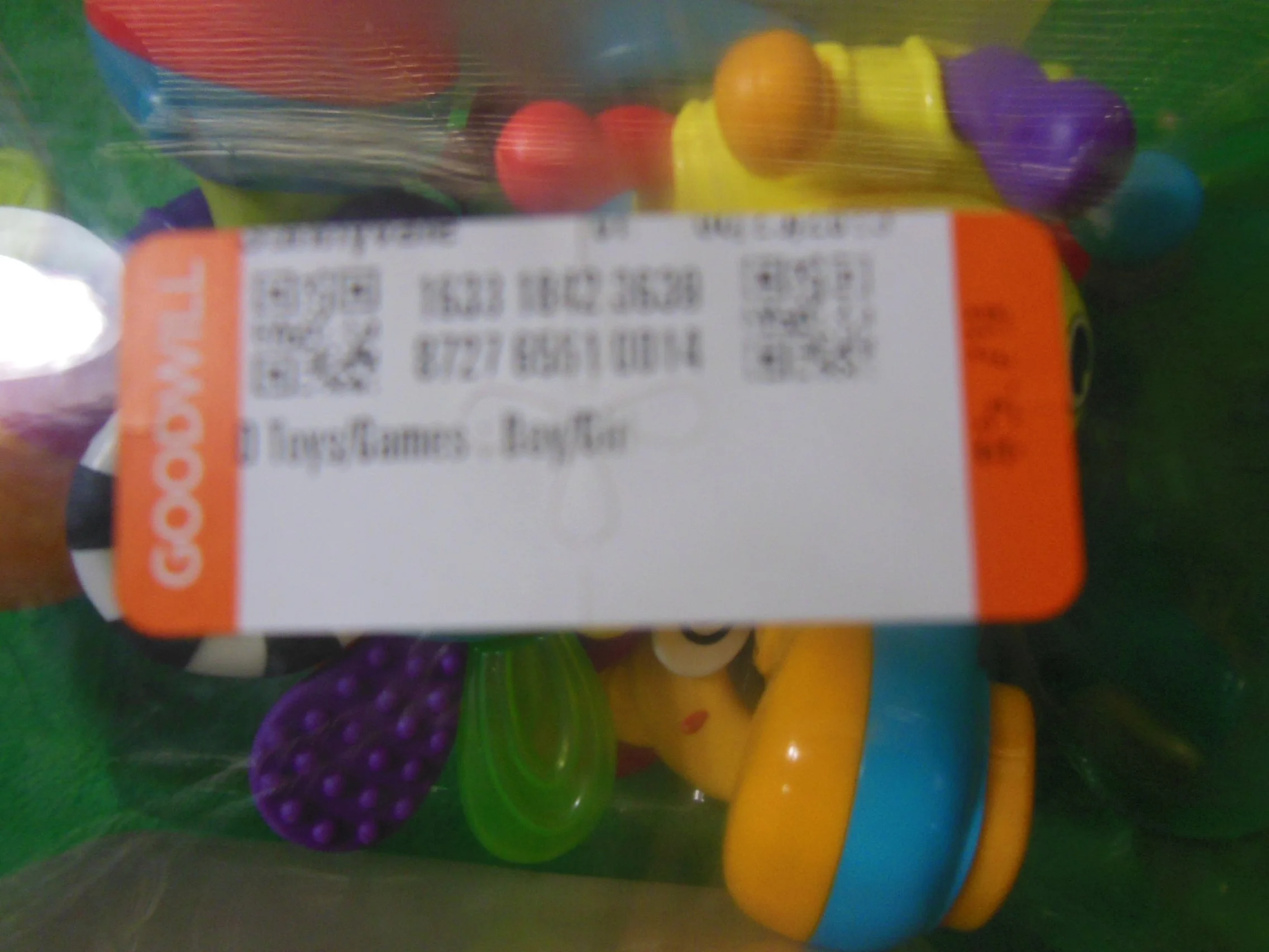 Bag of colorful teething toys including rings, crinkly animals, and textured shapes.