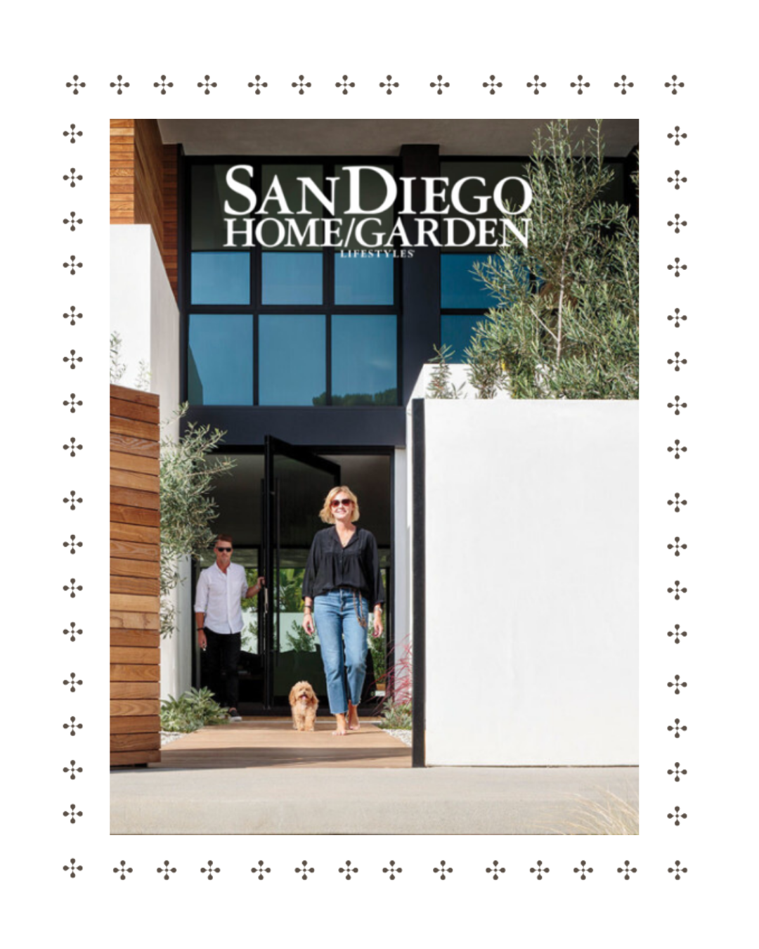 People walking out of a modern building with a sign reading 'San Diego Home Garden Lifestyles'; a woman with sunglasses and a man follow, with a dog on a leash.