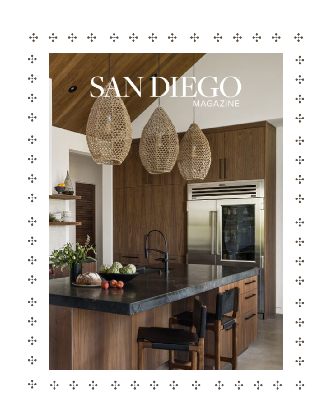Cover of San Diego Magazine featuring a modern kitchen with wooden cabinets, pendant lights, black countertop, and bar stools.