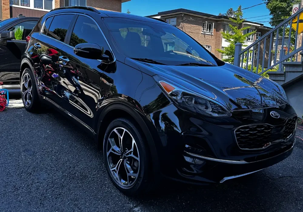 A black compact SUV parked on a driveway,