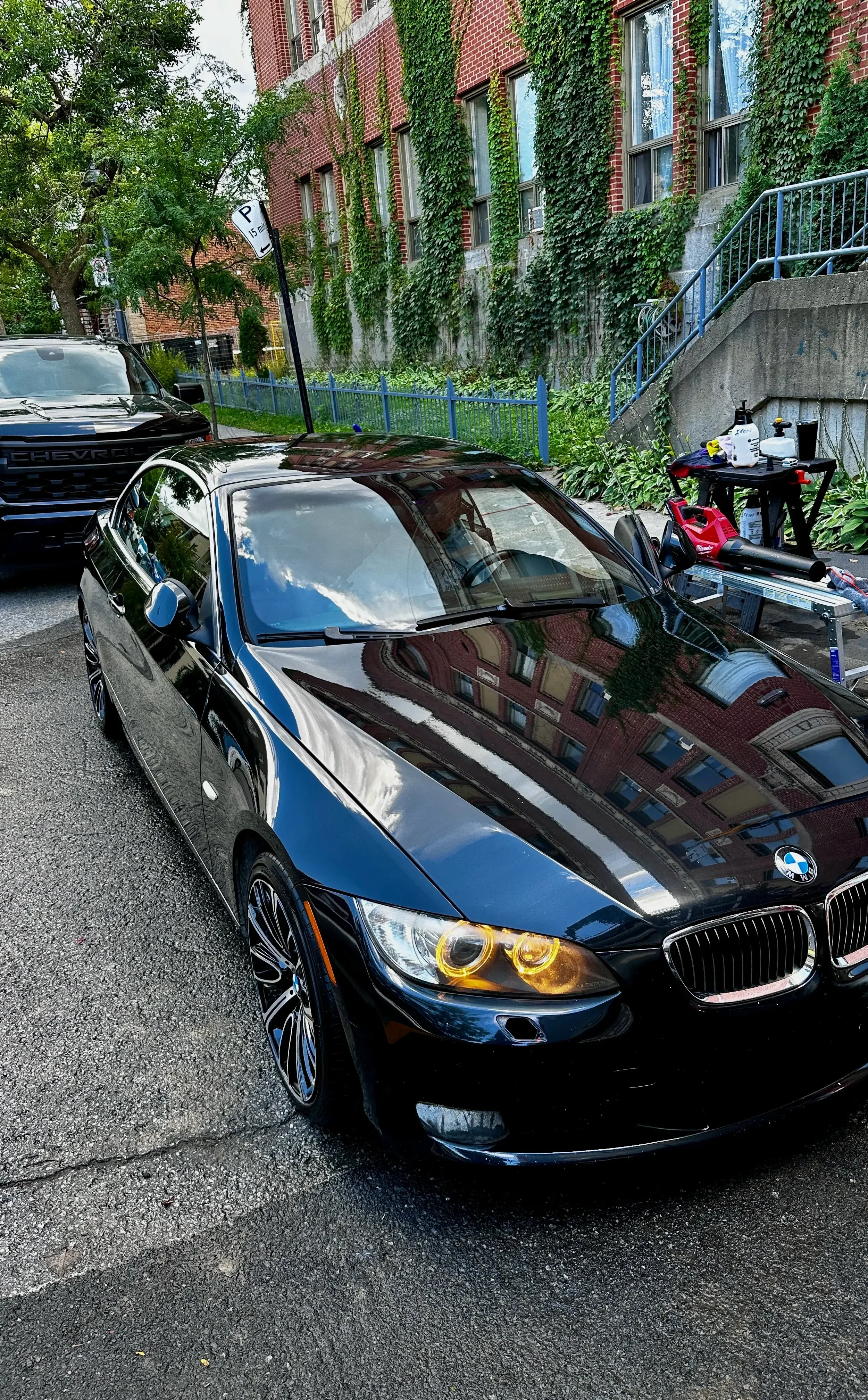 A shiny black BMW parked on a city street