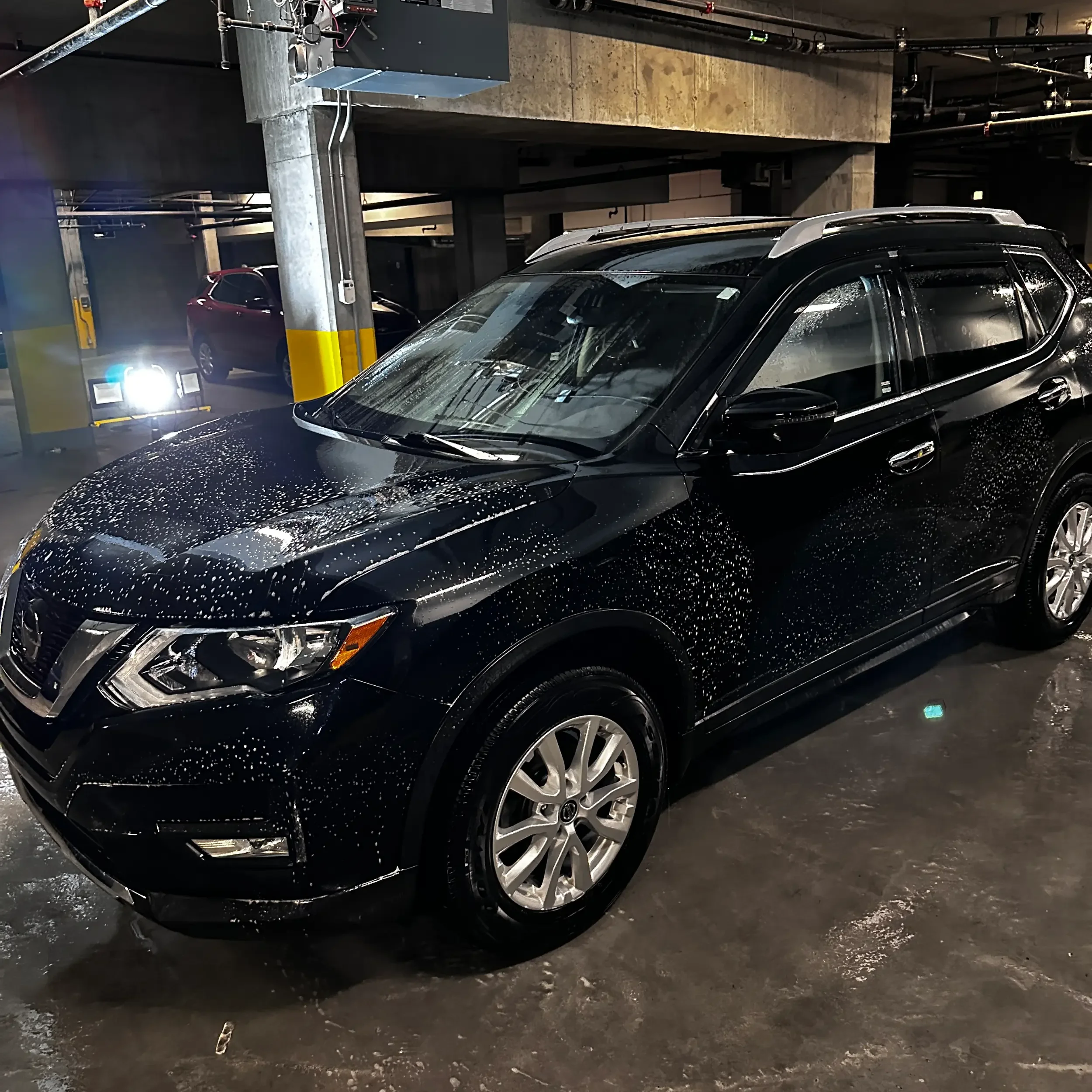 A black SUV parked in an indoor parking garage,
