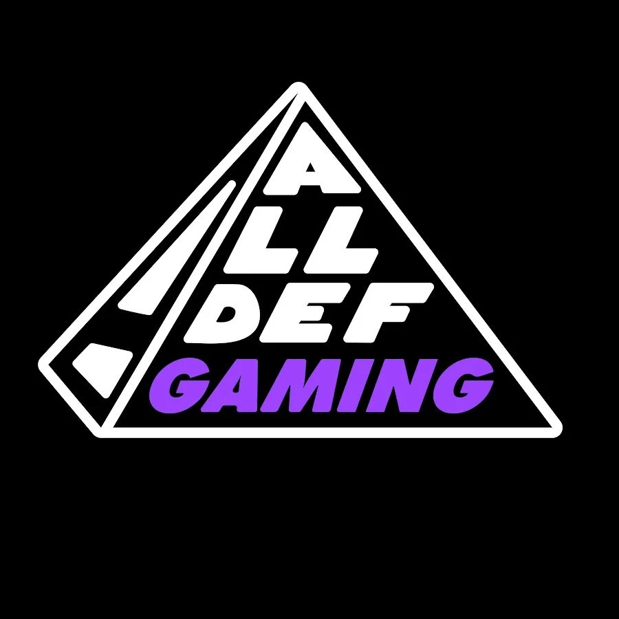 A triangular logo with the text 'ALL DEF GAMING' in white and purple, with a black background.