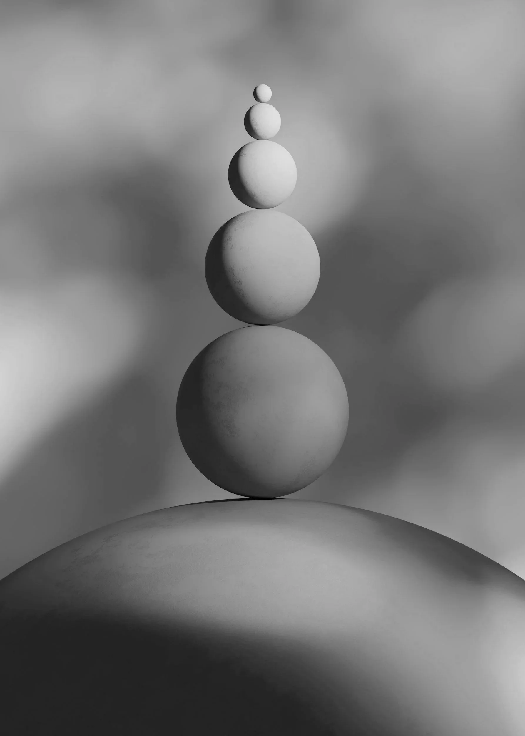 Five white spheres of varying sizes stacked vertically on a curved surface with a cloudy sky background, black and white photo.