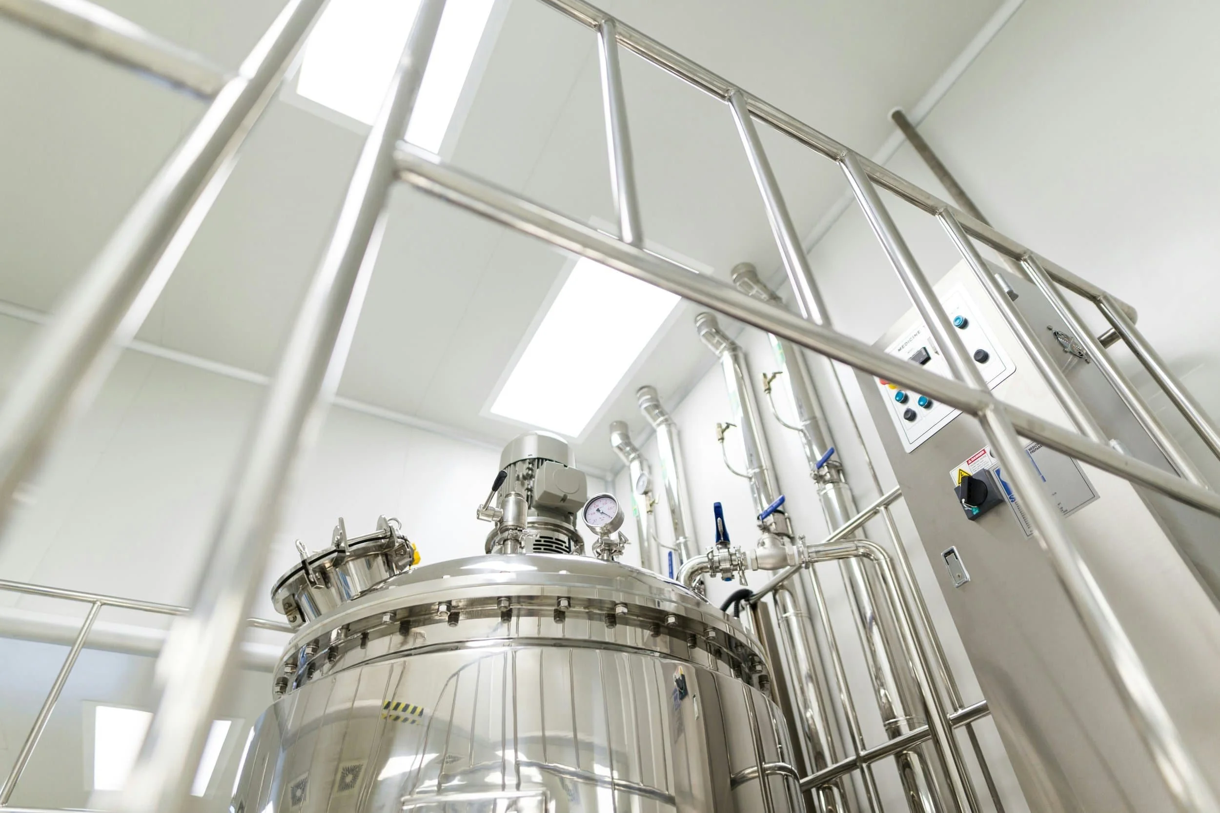Stainless steel essential oil distillation equipment inside a professional distillery facility.