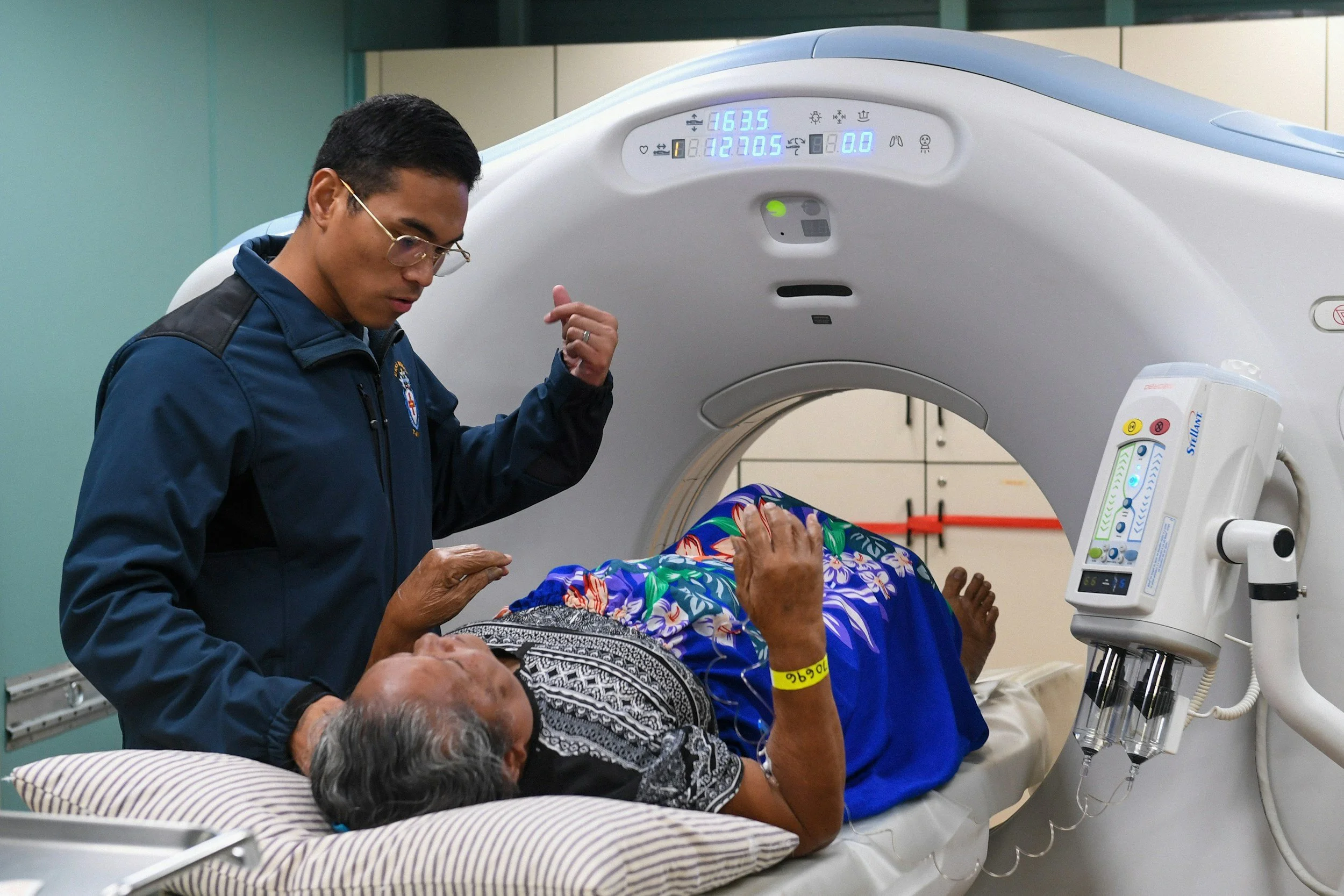 Woman in PET scanner with Dcotor speaking to her