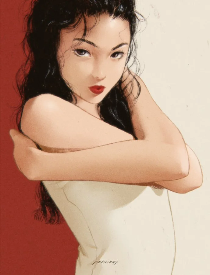 An artistic portrait of a woman with long dark hair, wearing red lipstick, against a background that is half red and half white, with her arms crossed over her chest and her face turned towards the camera.