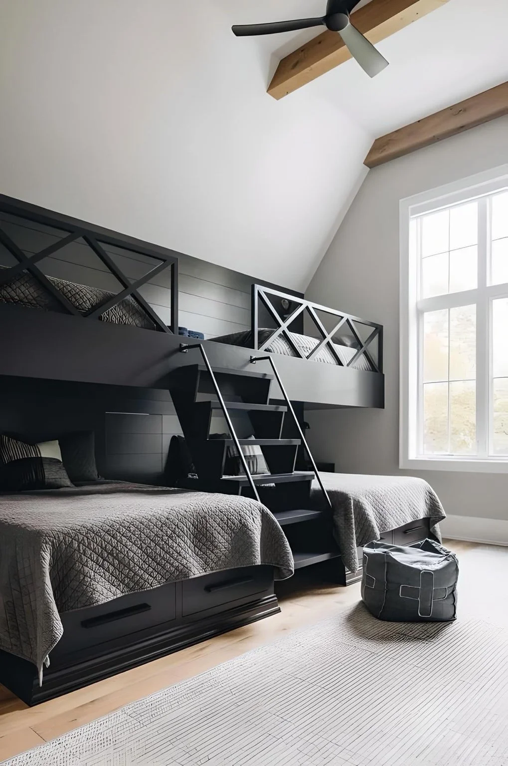 Vaulted custom bunk room with black built-ins, multiple sleeping zones, integrated stairs, and storage.