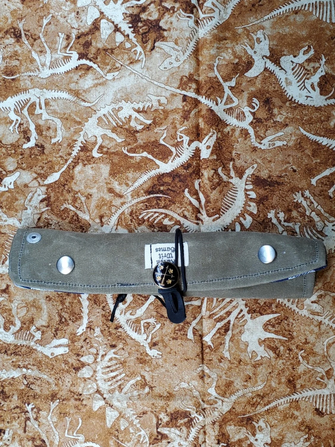 A waxed canvas Dice Roll rolled up and sinched for travel.