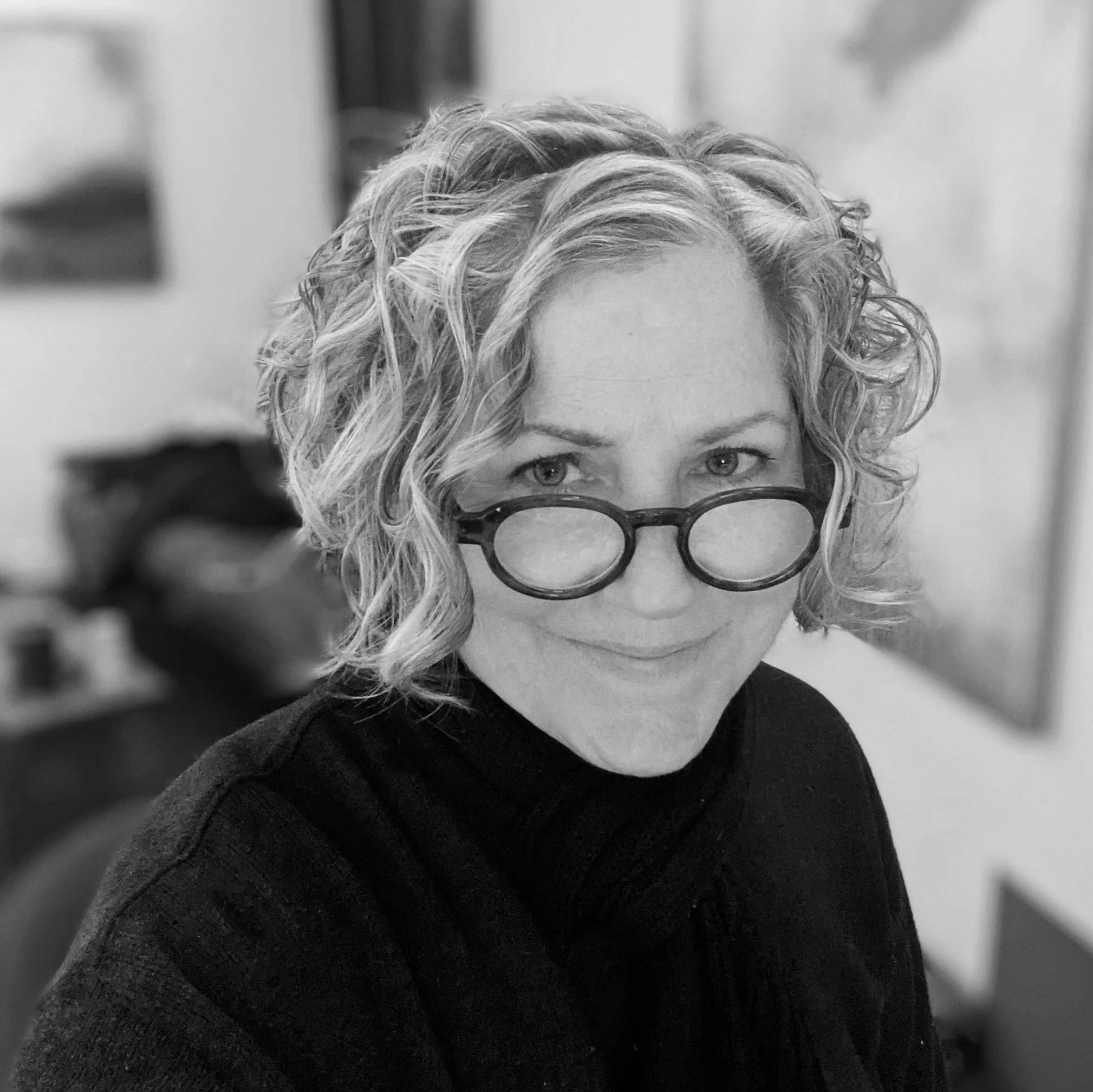 A portrait of artist Kerry Schroeder, smiling at the camera, in a black and white photo.