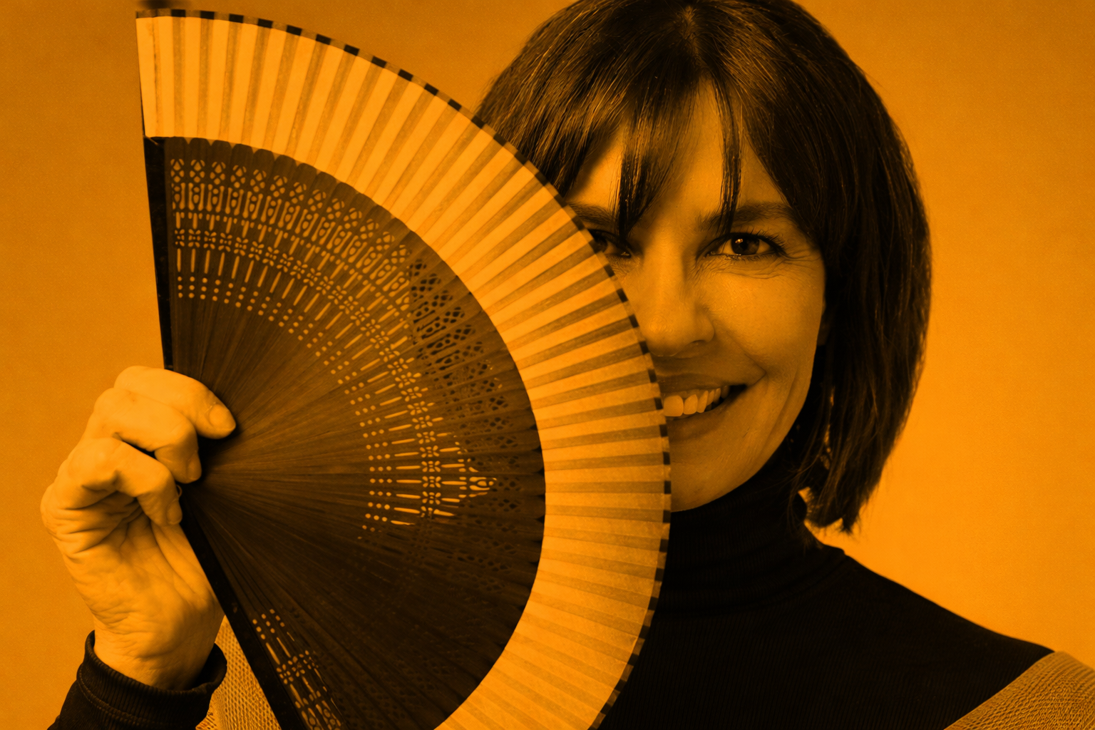 A woman with dark hair holding an Asian-style fan over her face, smiling with one eye visible, against a yellow background.