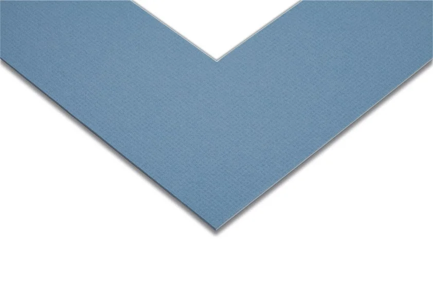 Close-up of a blue, textured, triangular sheet of adhesive material with a white backing paper partially peeled back.