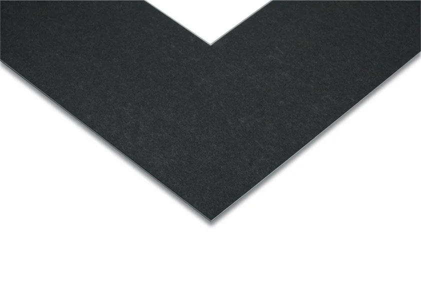 Close-up of a black paper or cardboard with a pointed corner against a white background.