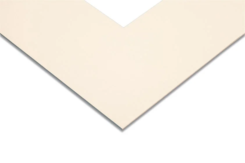 Close-up of a corner of a blank white piece of paper or card on a white background.
