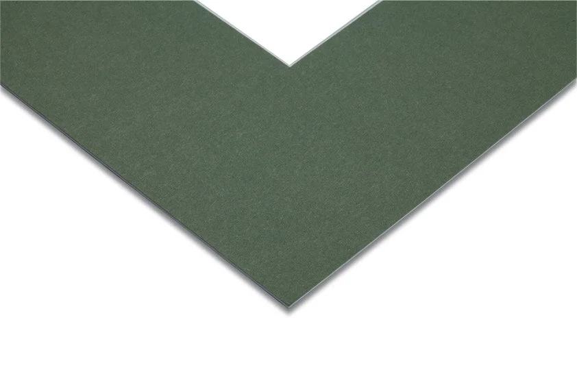 Close-up of a green corner of a foam or rubber mat with a smooth surface, showing its layered construction.