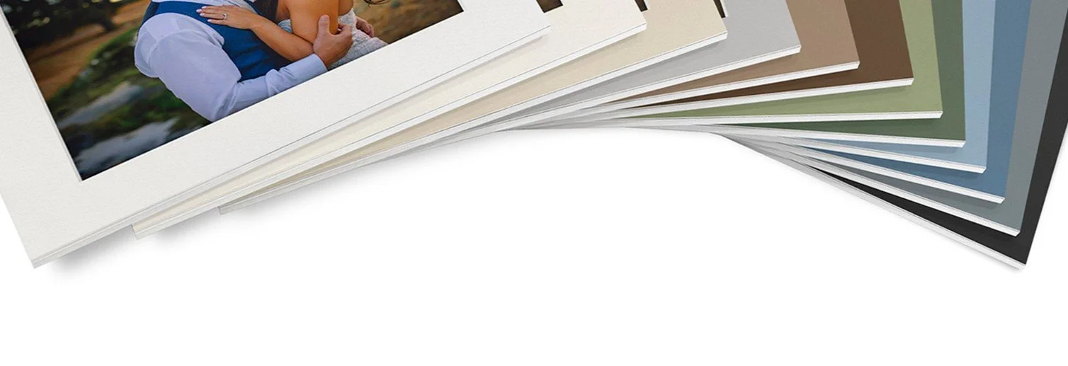 A stack of photo albums with colorful covers, showing a family photo on the top album.