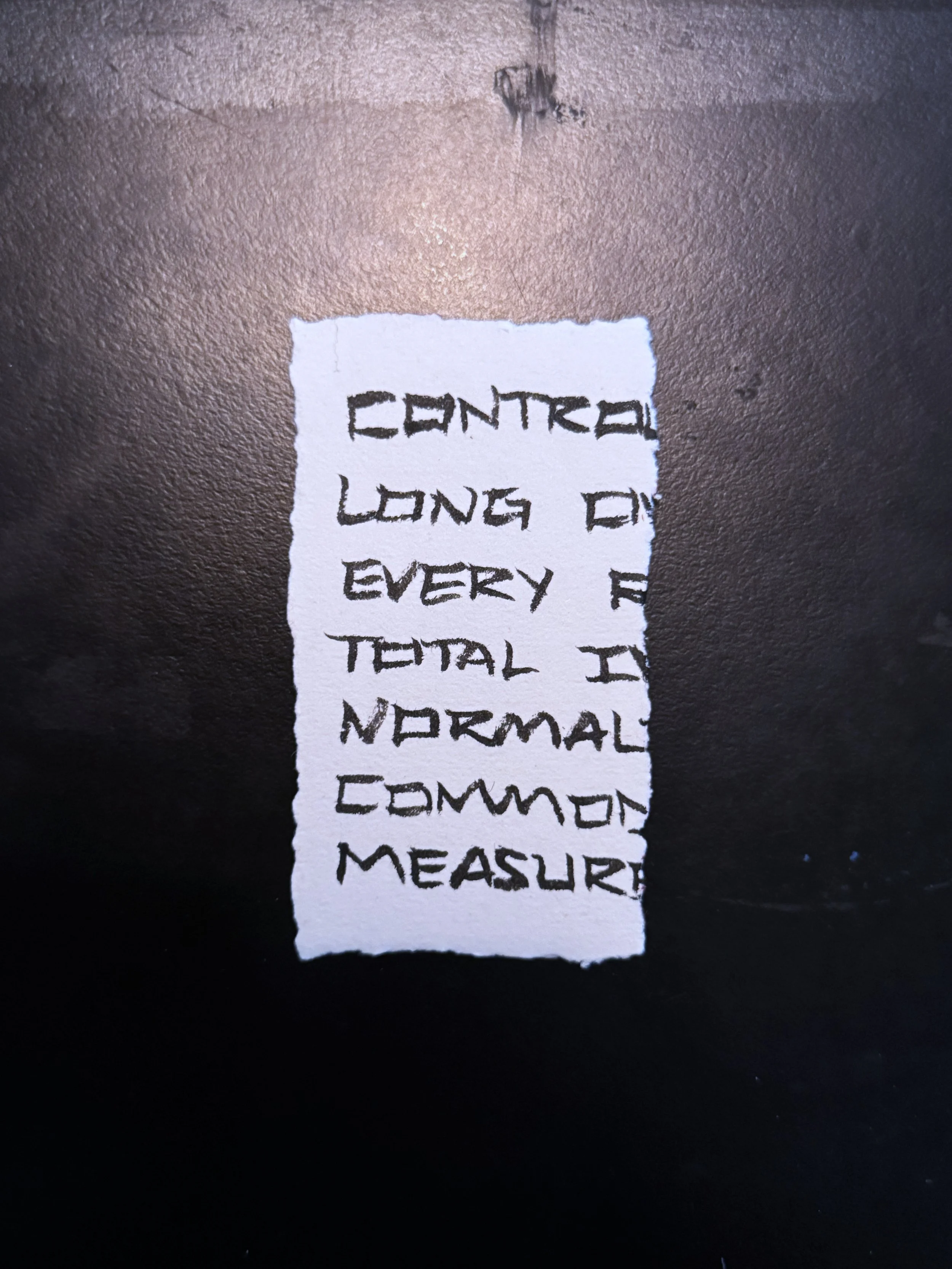 A handwritten note on a torn piece of paper with the words: 'Center long of every total in normal common measure'.
