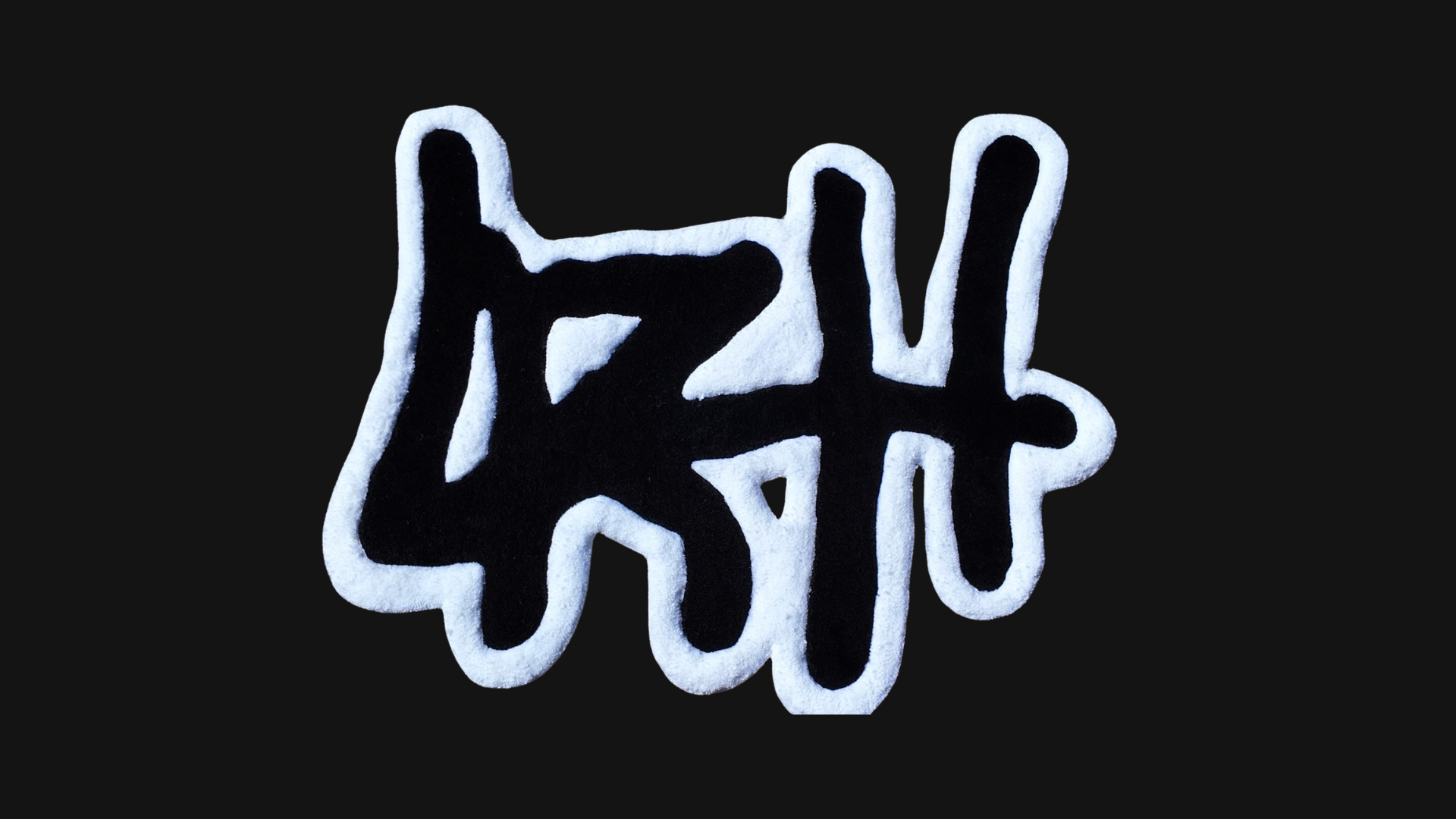 A custom logo rug of the brand LRH in white in black on a black background. 